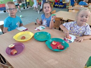 Zuzia, Filip i Zuzanna stemplują jabłkami.
