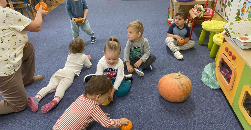 nauczycielka rozdaje dzieciom małe dynie , każde z nich trzyma je w rączkach