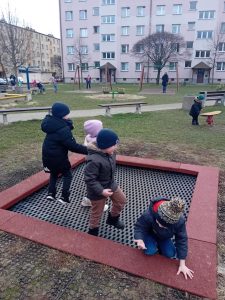 Czwórka dzieci skacze na trampolinie.